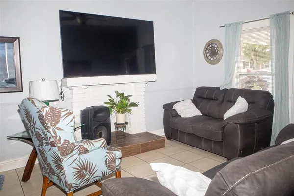 a living room with furniture a fireplace and a window
