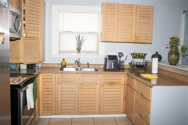 a kitchen with stainless steel appliances granite countertop a sink and a white wooden cabinets