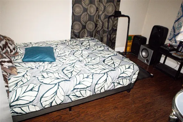 a bedroom with a bed window and a wooden floor