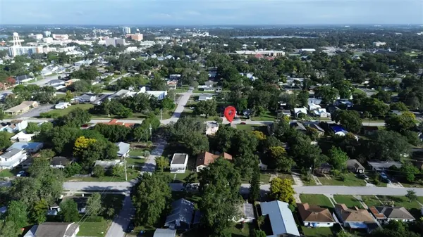 an aerial view of residential houses with outdoor space and trees