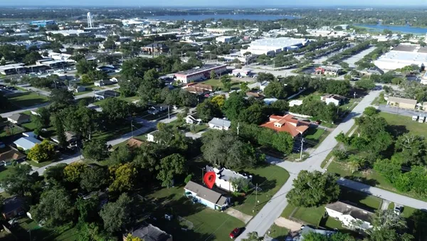 an aerial view of residential houses with outdoor space and trees