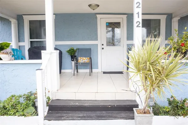 a view of front door of house and potted plants