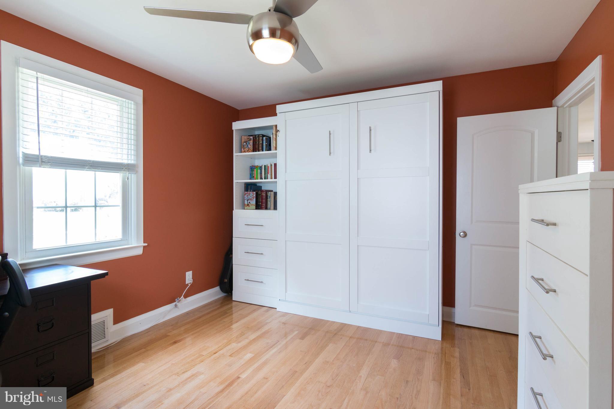 1234 Oakland Terrace Road Baltimore, MD 21227 - Photo 12 of 30 an empty room with wooden floor cabinet and windows