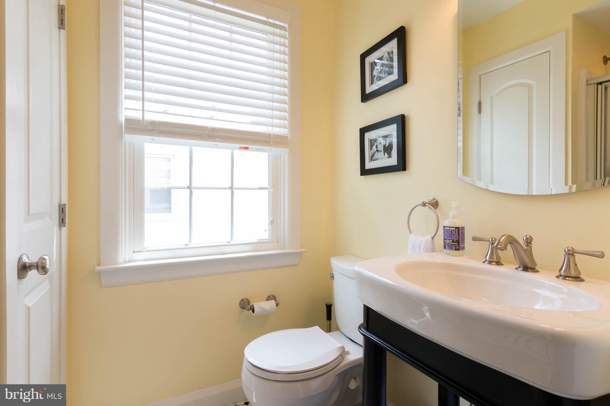 1234 Oakland Terrace Road Baltimore, MD 21227 - Photo 13 of 30 a bathroom with a toilet a sink and a window