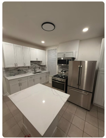 1649 West Garfield Boulevard, Unit 2 Chicago, IL 60636 - Photo 3 of 14 a kitchen with granite countertop a refrigerator a sink and white cabinets