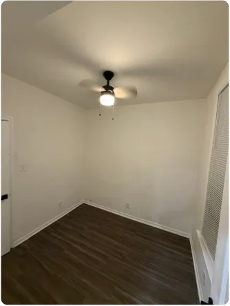 a view of an empty room with wooden floor