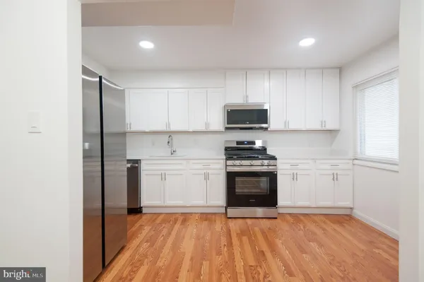 a kitchen with stainless steel appliances a refrigerator sink and cabinets