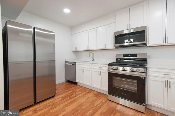 a stove sitting inside of a kitchen with stainless steel appliances