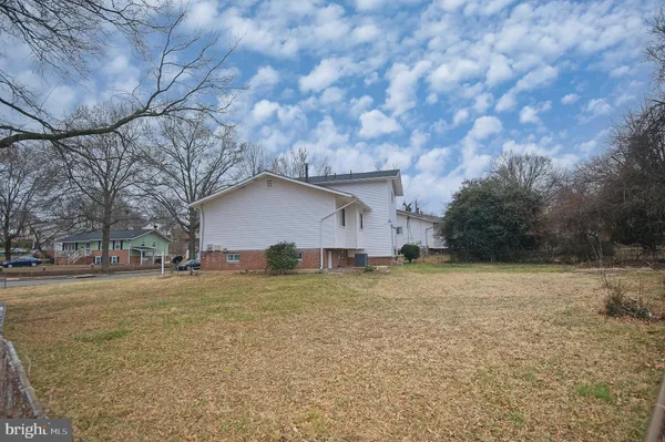 a view of a yard in front of a house with a large tree