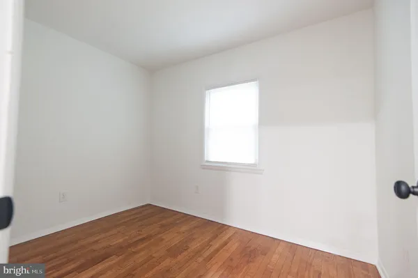 a view of an empty room with closet and entryway