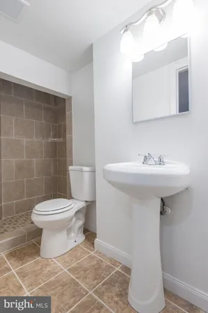 a view of an empty room with wooden floor and a fireplace