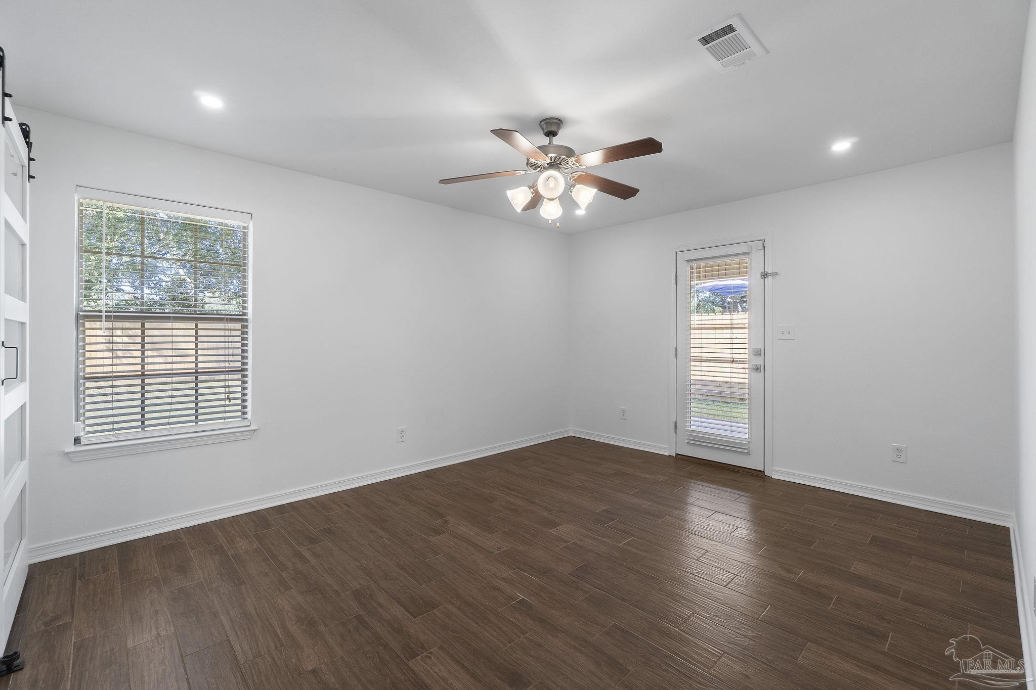 576 Edith Lane Pensacola, FL 32534 - Photo 18 of 38 an empty room with wooden floor chandelier fan and windows
