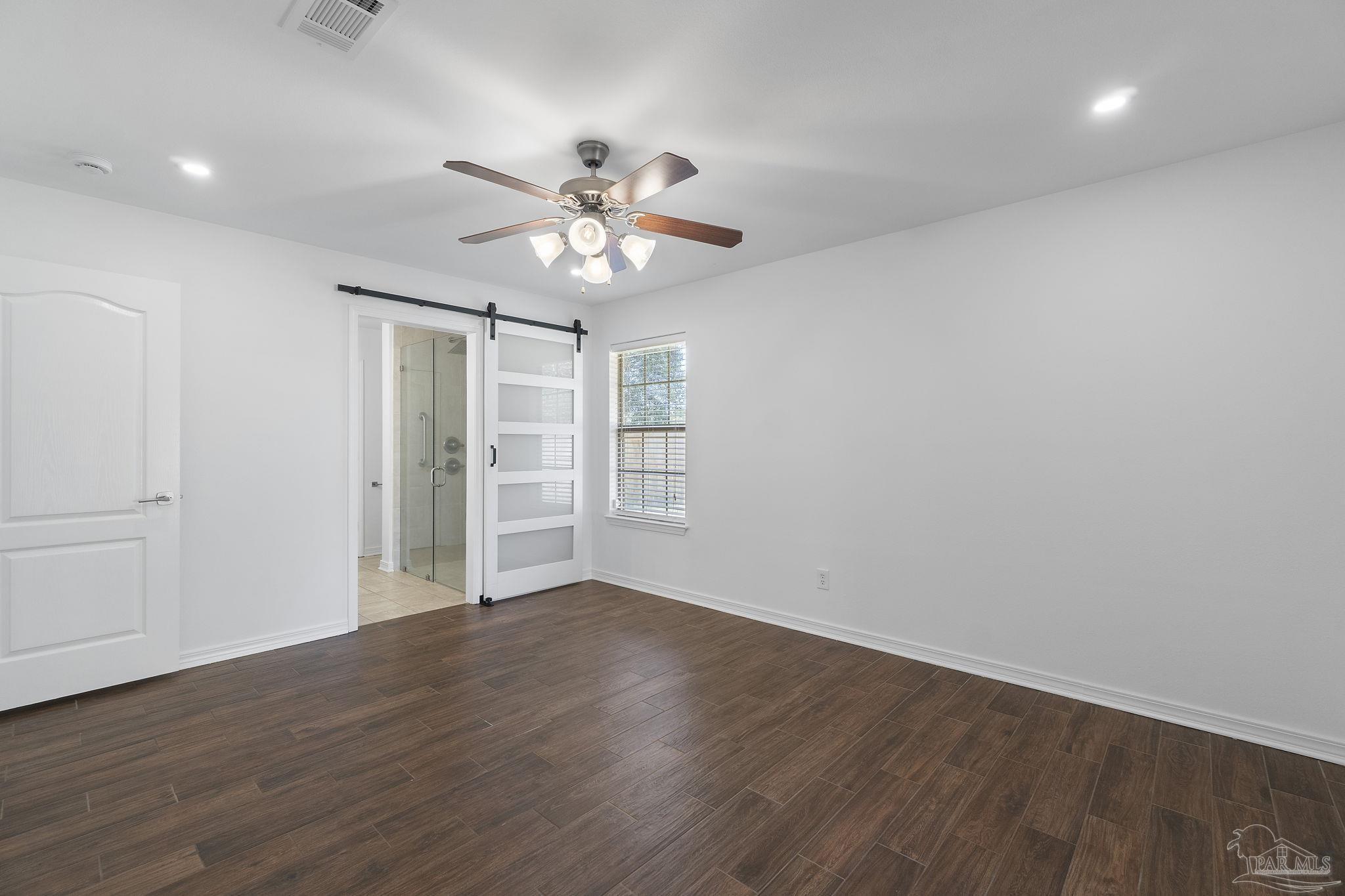 576 Edith Lane Pensacola, FL 32534 - Photo 19 of 38 an empty room with wooden floor chandelier fan and windows
