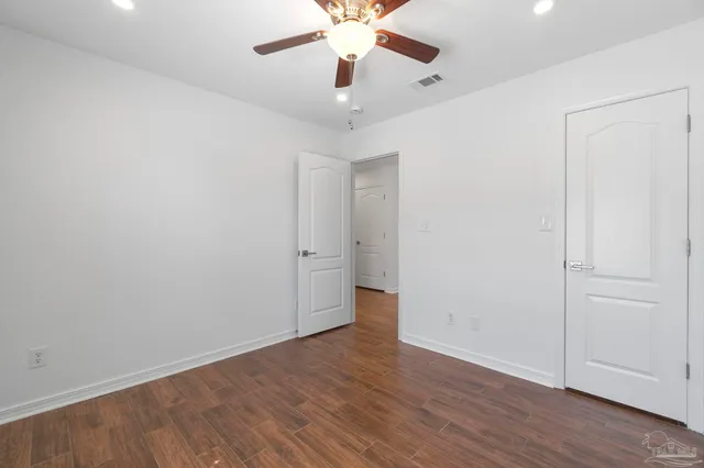 an empty room with wooden floor and closet