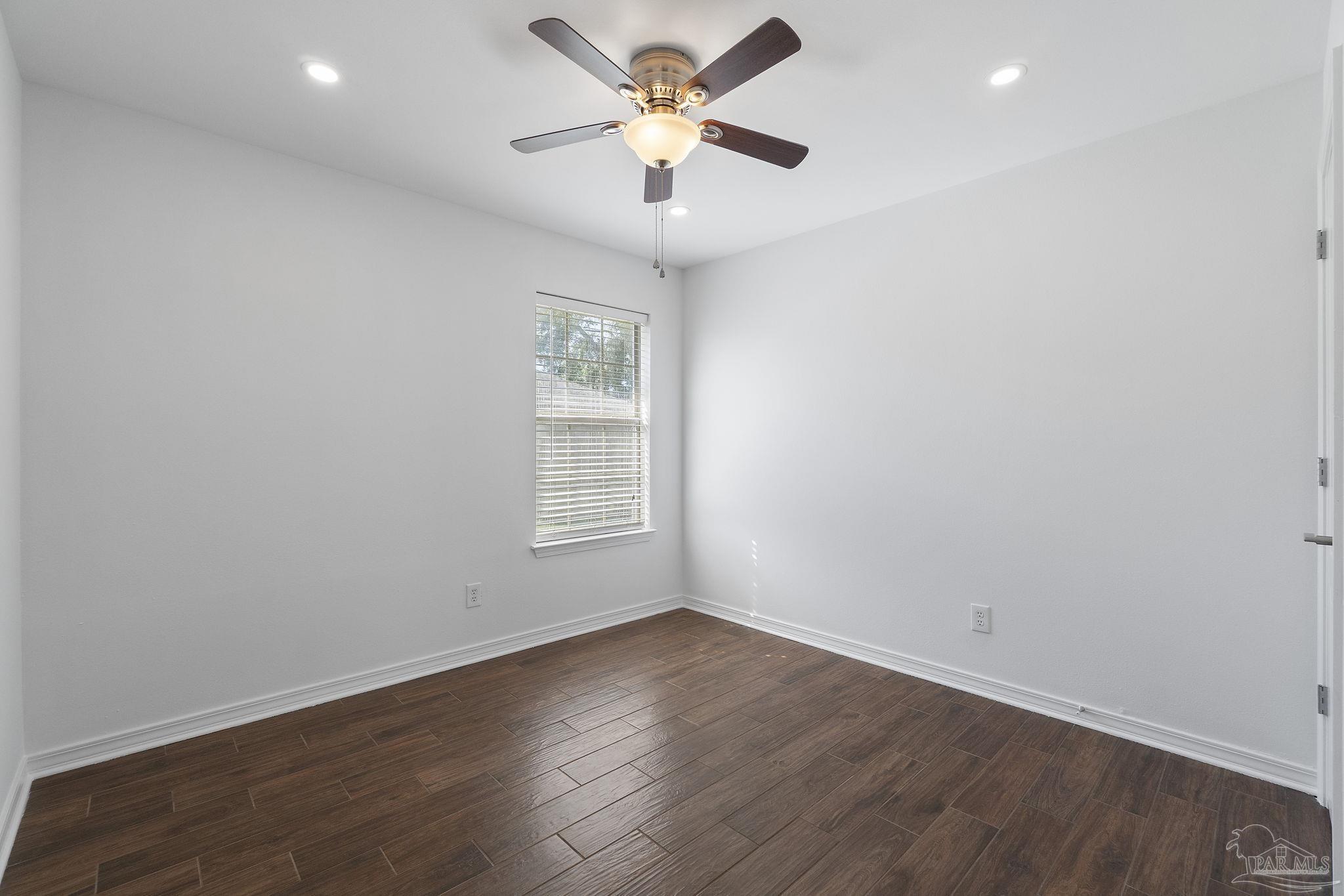 576 Edith Lane Pensacola, FL 32534 - Photo 29 of 38 an empty room with wooden floor and a ceiling fan