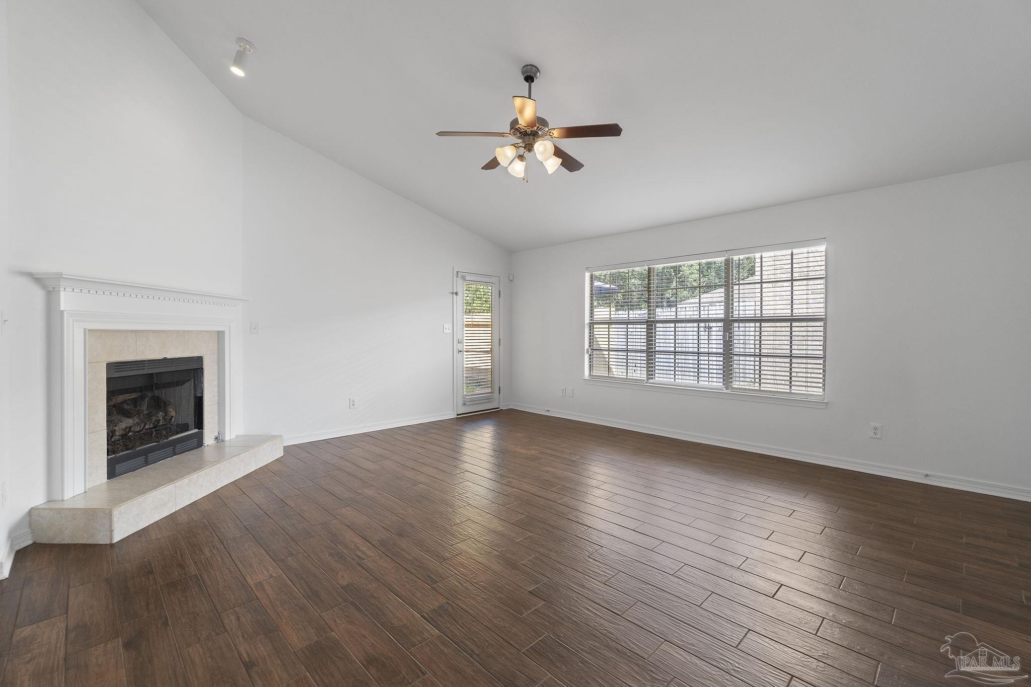 576 Edith Lane Pensacola, FL 32534 - Photo 9 of 38 a view of an empty room with wooden floor fireplace and a window