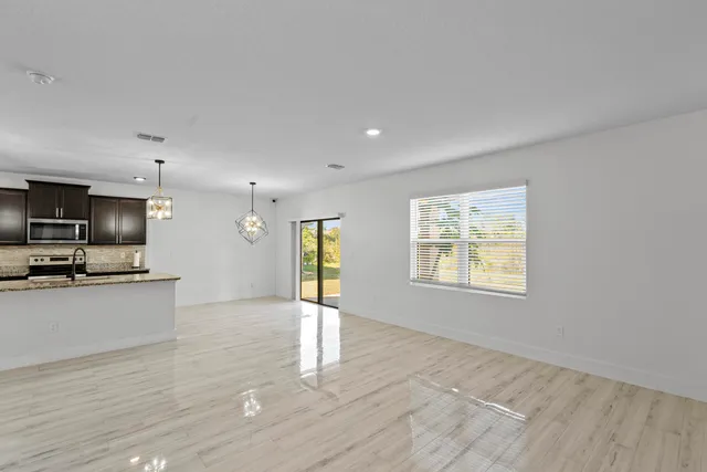 a view of kitchen with microwave refrigerator and wooden floor