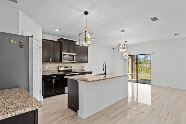 a kitchen with stainless steel appliances granite countertop a sink stove and refrigerator