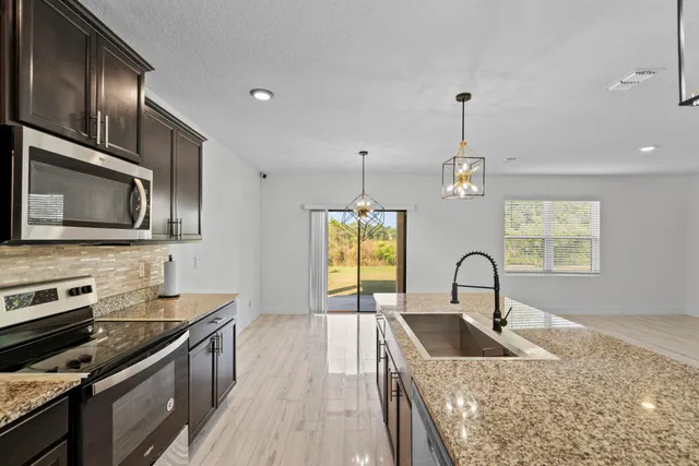 a kitchen with a stove a sink and a microwave