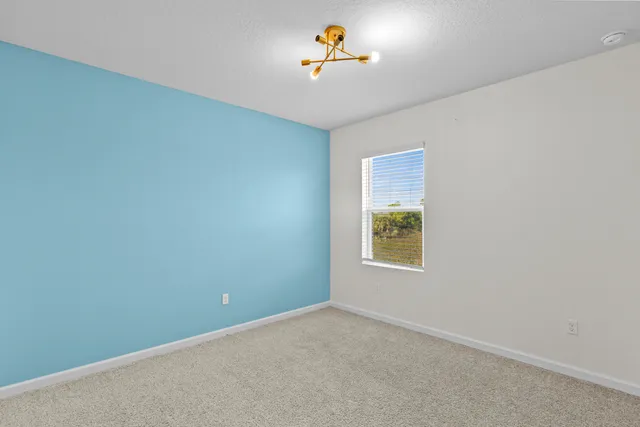 an empty room with a window and a ceiling fan