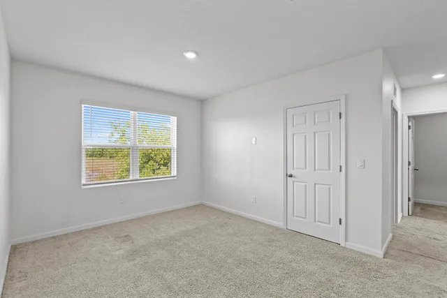 an empty room with windows and closet