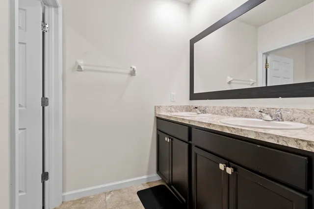 a bathroom with a granite countertop sink and a mirror
