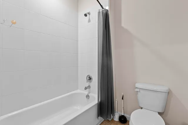 a white toilet sitting next to a shower curtain