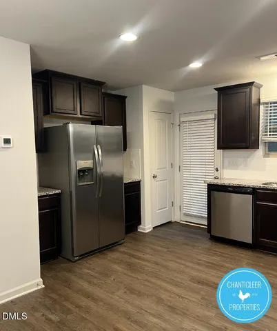 a kitchen with stainless steel appliances granite countertop a refrigerator and a stove top oven