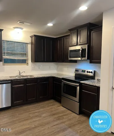 a kitchen with stainless steel appliances granite countertop a stove a sink dishwasher a refrigerator and a microwave oven