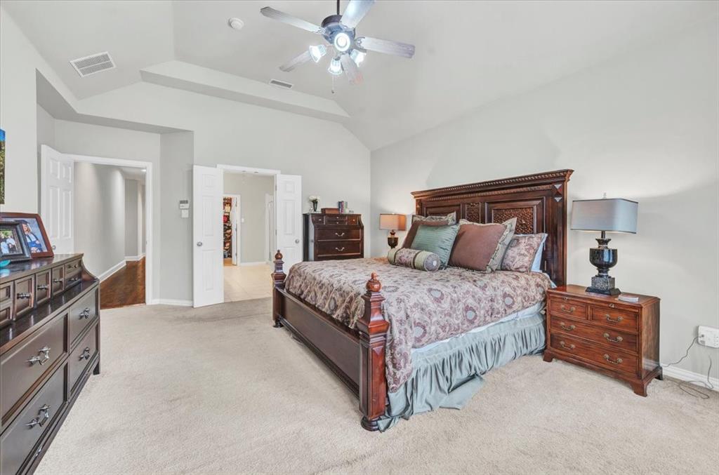 2015 Midhurst Drive Allen, TX 75013 - Photo 14 of 37 a spacious bedroom with a bed and a chandelier