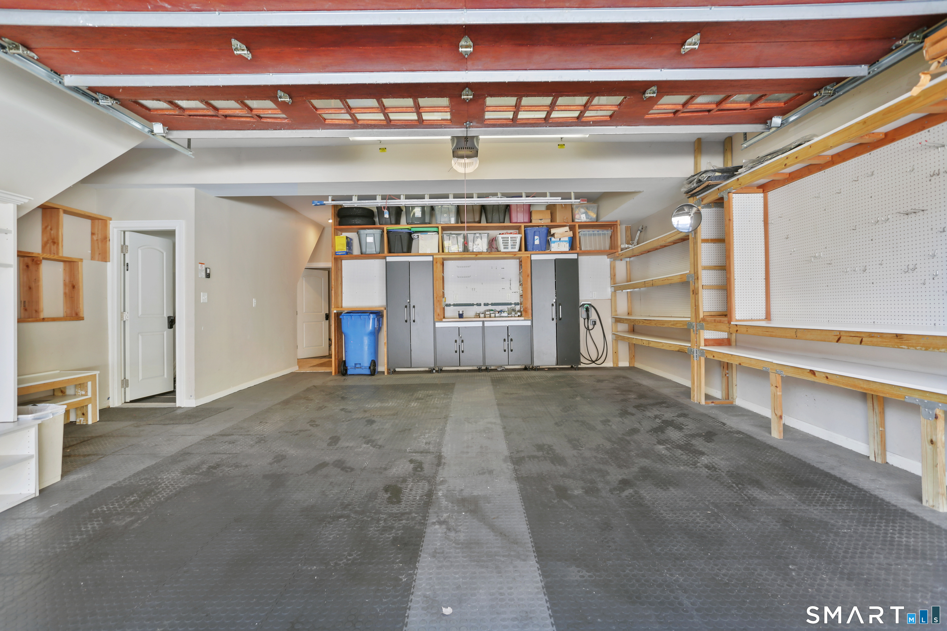 2 Trout Creek Road, Unit 2 Shelton, CT 06484 - Photo 32 of 38 Two-Car Garage Oversized two-car garage featuring Supra Tile flooring, extensive built-in storage, shelving, and dedicated workspace. Includes a Level 2 EV charger and convenient elevator access to all four levels of the home.