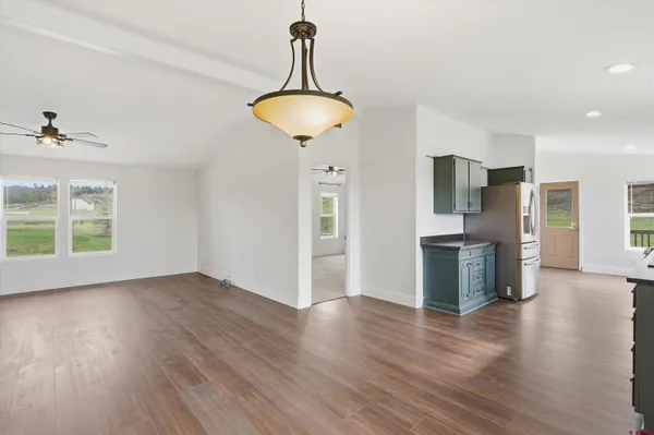 a view of a kitchen with a sink refrigerator and wooden floor