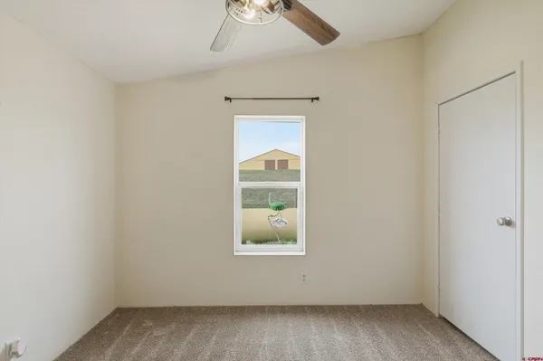 an empty room with a window and a fan
