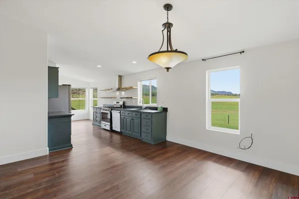 a kitchen with stainless steel appliances kitchen island a refrigerator and a view of living room