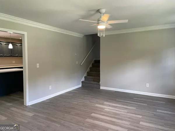 a view of a livingroom with wooden floor and staircase