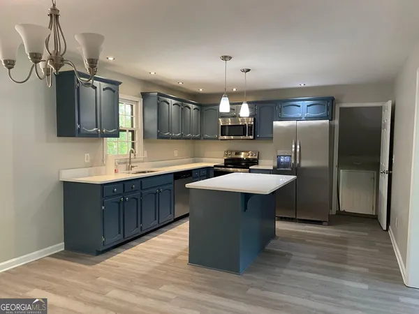 a kitchen with stainless steel appliances a sink a stove a refrigerator and cabinets