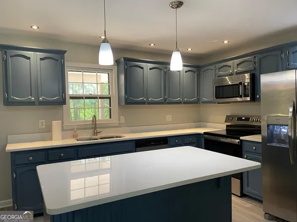 a kitchen with a sink a counter space cabinets and appliances