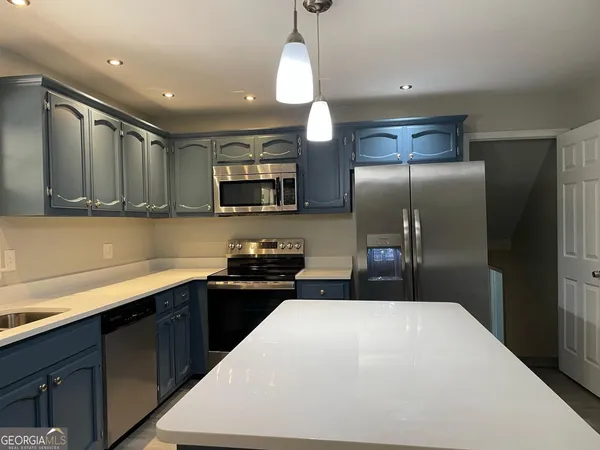 a kitchen with stainless steel appliances a sink dishwasher a refrigerator and a microwave