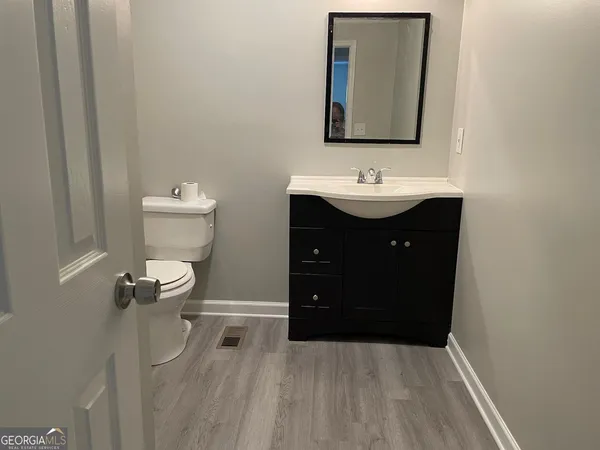 a bathroom with a sink vanity and toilet