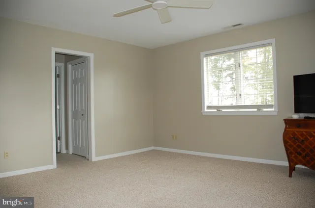 a view of room with window and a ceiling fan