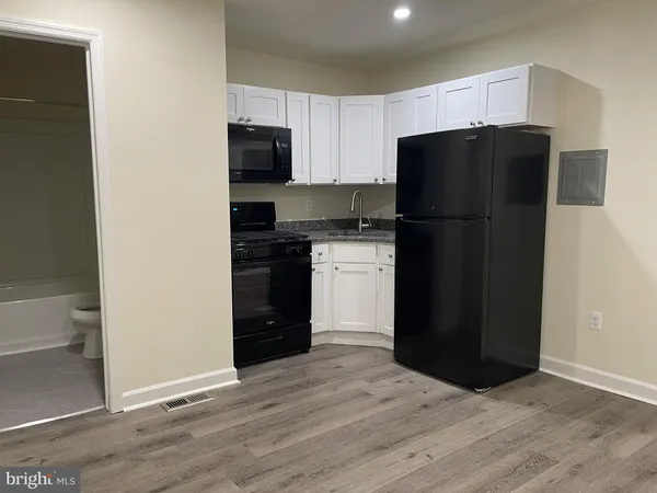 a kitchen with a refrigerator and a stove top oven