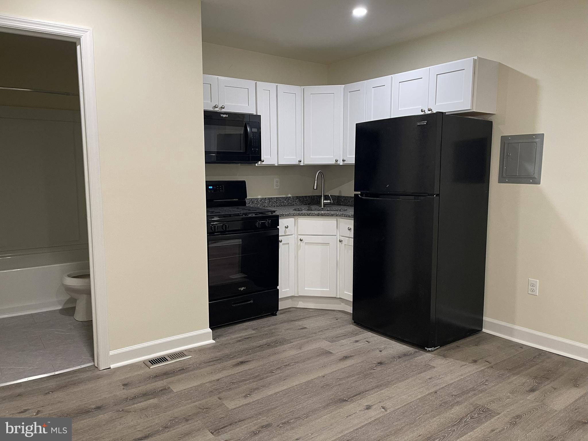 a kitchen with a refrigerator and a stove top oven