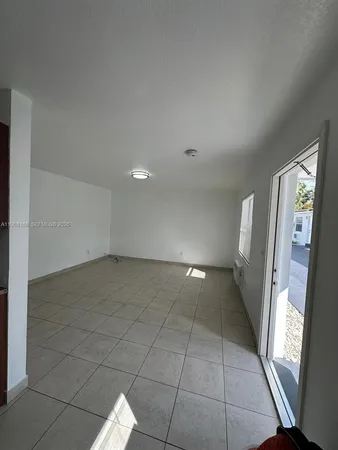 a view of a livingroom with an empty space and a window