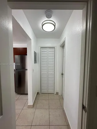 a view of a hallway with closet and a bathroom