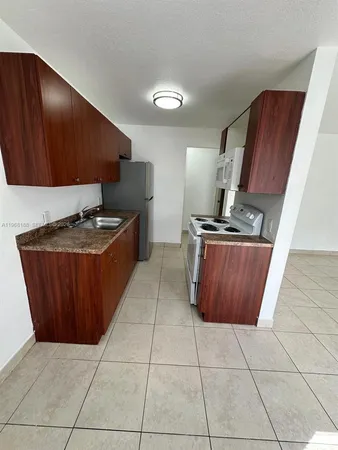 a kitchen with granite countertop a stove a sink and a microwave