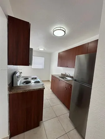 a kitchen with granite countertop a refrigerator stove and sink