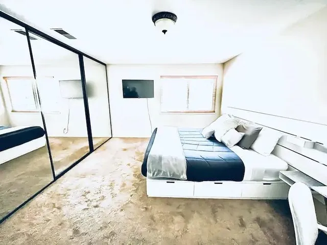 a bedroom with a bed and a large window