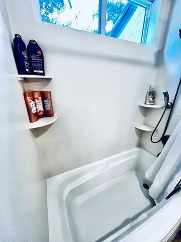 a bathroom with a bathtub and a closeup of a window