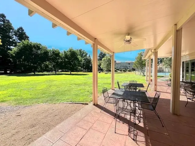 a view of a patio with a table chairs and garden