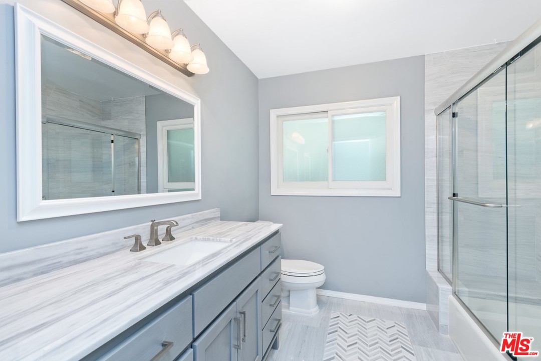 9614 Heather Road Beverly Hills, CA 90210 - Photo 13 of 25 a bathroom with a granite countertop sink toilet and shower